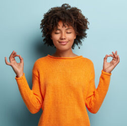 mindful-peaceful-afro-american-woman-meditates-indoor-keeps-hands-mudra-gesture-has-eyes-closed